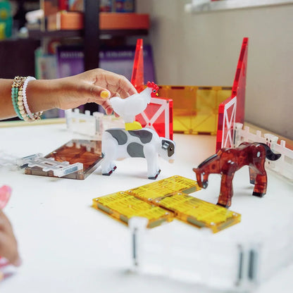 Toy farm set with animals and a hand interacting 