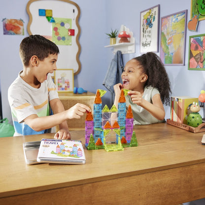 Two children playing with colorful magnetic building blocks at a table in a classroom setting