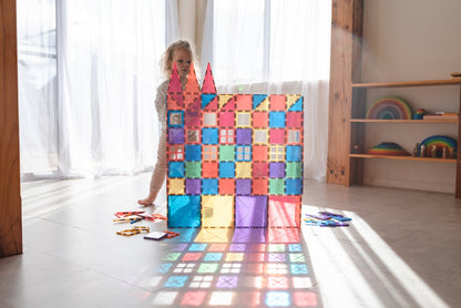 Child building a colorful magnetic tile tower with Connetix magnetic tiles