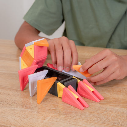 Child's hands assembling a colorful geometric toy structure