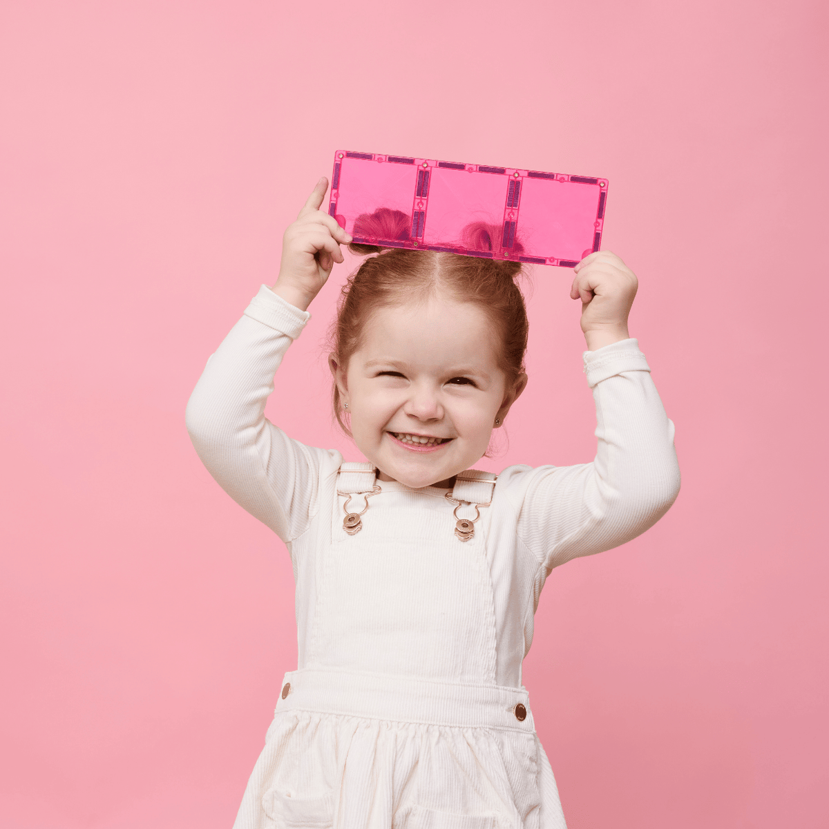 Child holding a pink suitcase