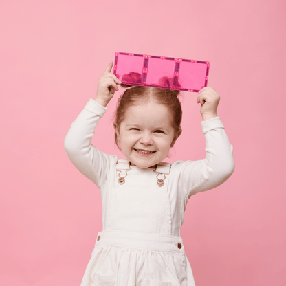 Child holding a pink suitcase