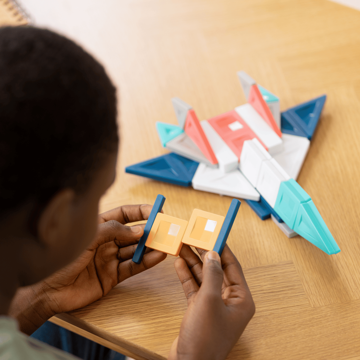 Child playing with colorful geometric shapes 