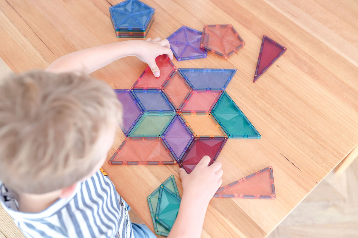 Child playing with colorful magnetic tiles