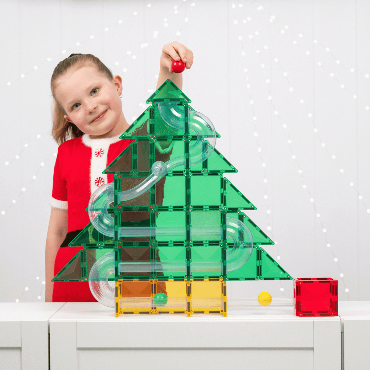 Child playing with Connetix Christmas magnetic tiles and building a festive tree