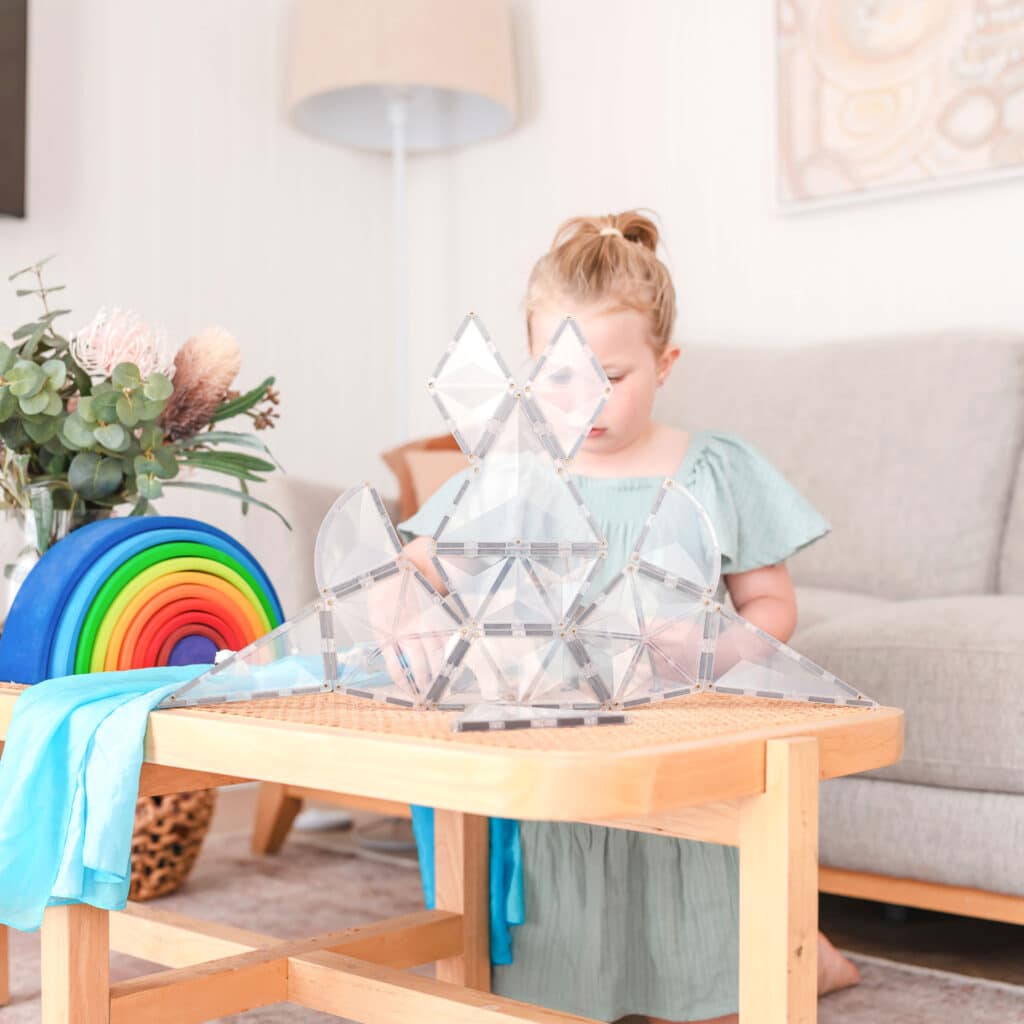 Child playing with a crystal pyramid 