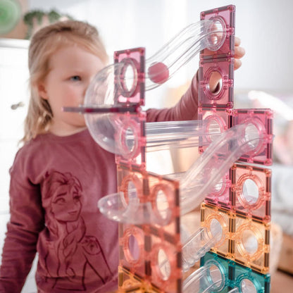 Child playing with a transparent and pink geometric toy structure