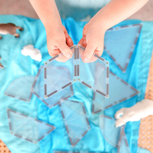Children's hands holding a geometric transparent puzzle 