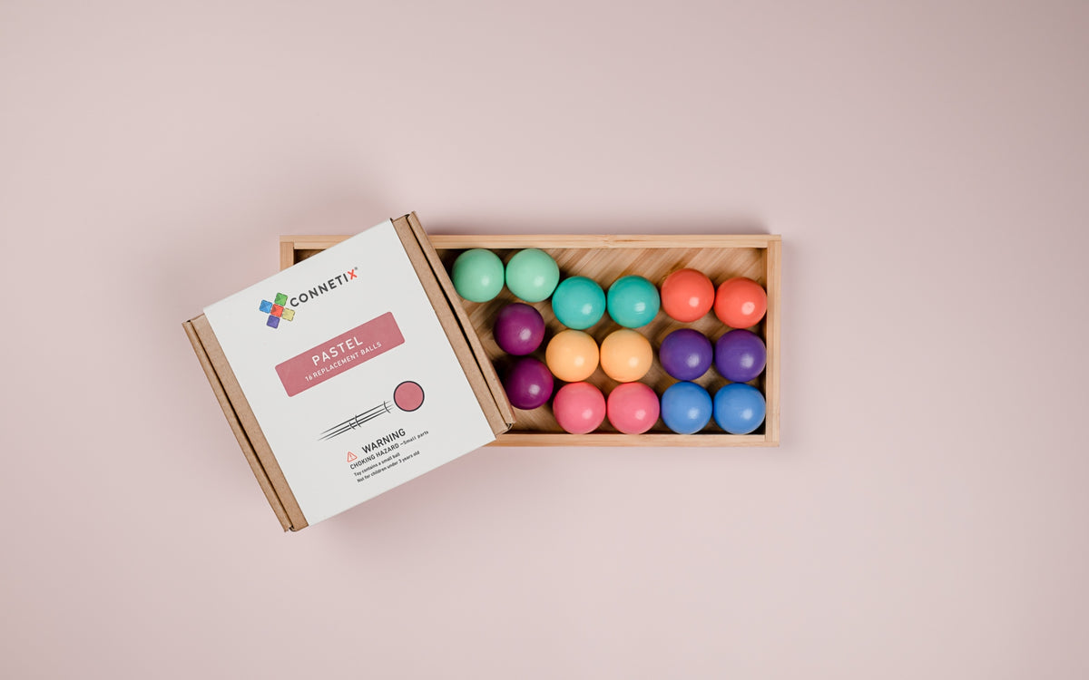 Colorful balls in a wooden box with a Connect4 product packaging 