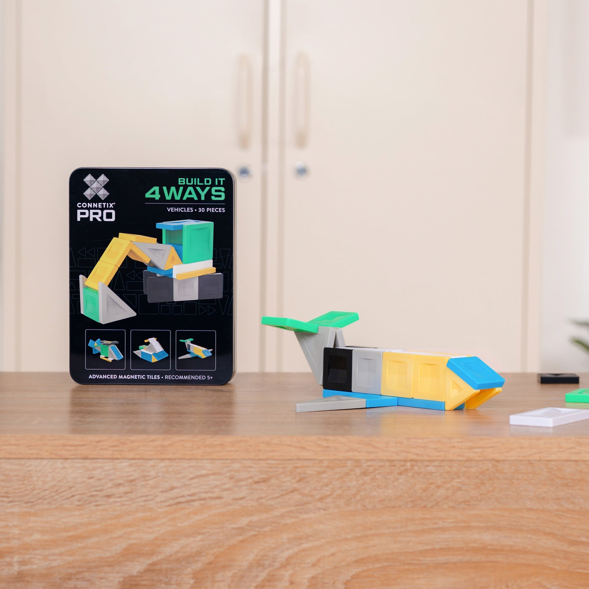 A toy building set box labeled 'Element Pro Build It 4Ways' stands 