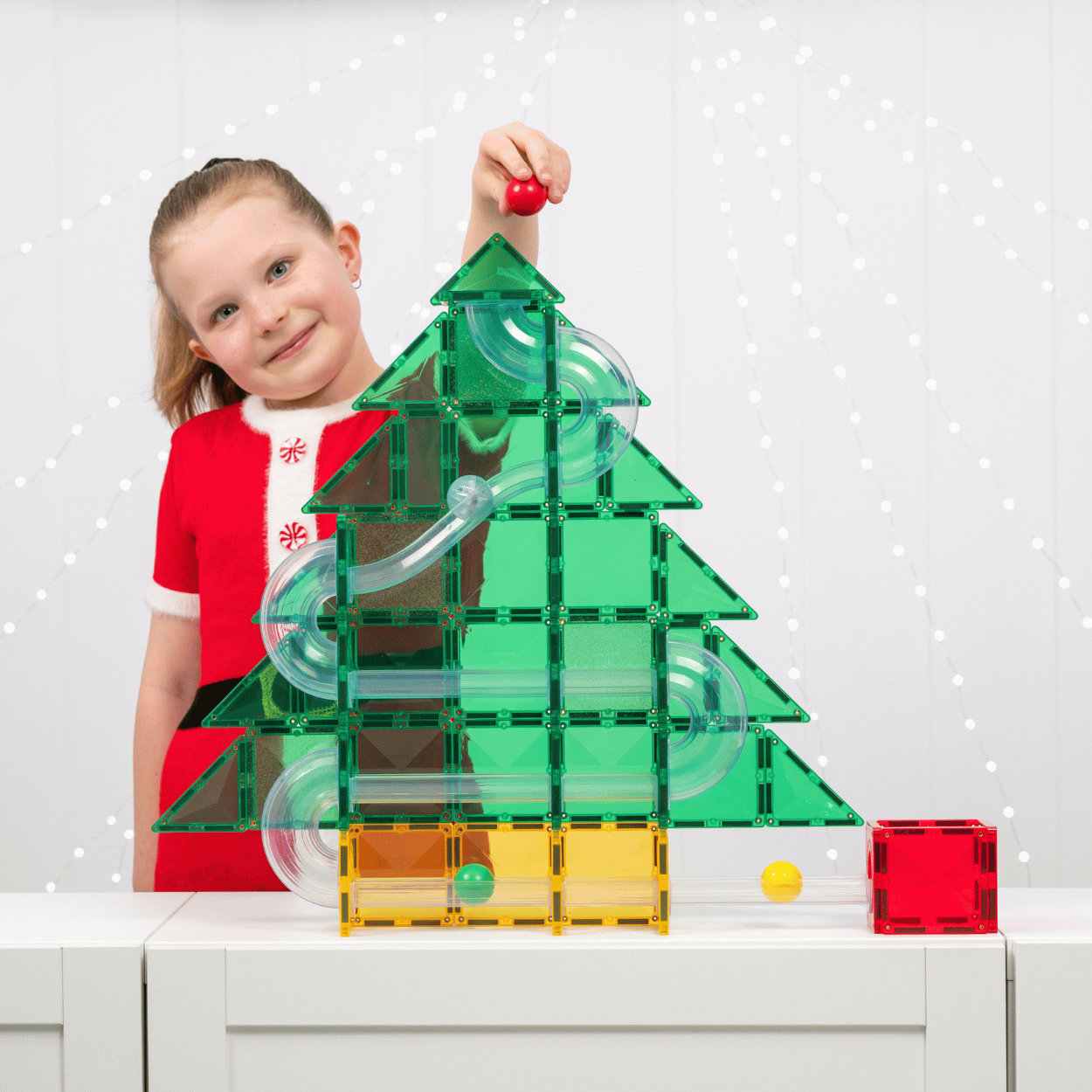 Child playing with Connetix Christmas magnetic tiles and building a festive tree
