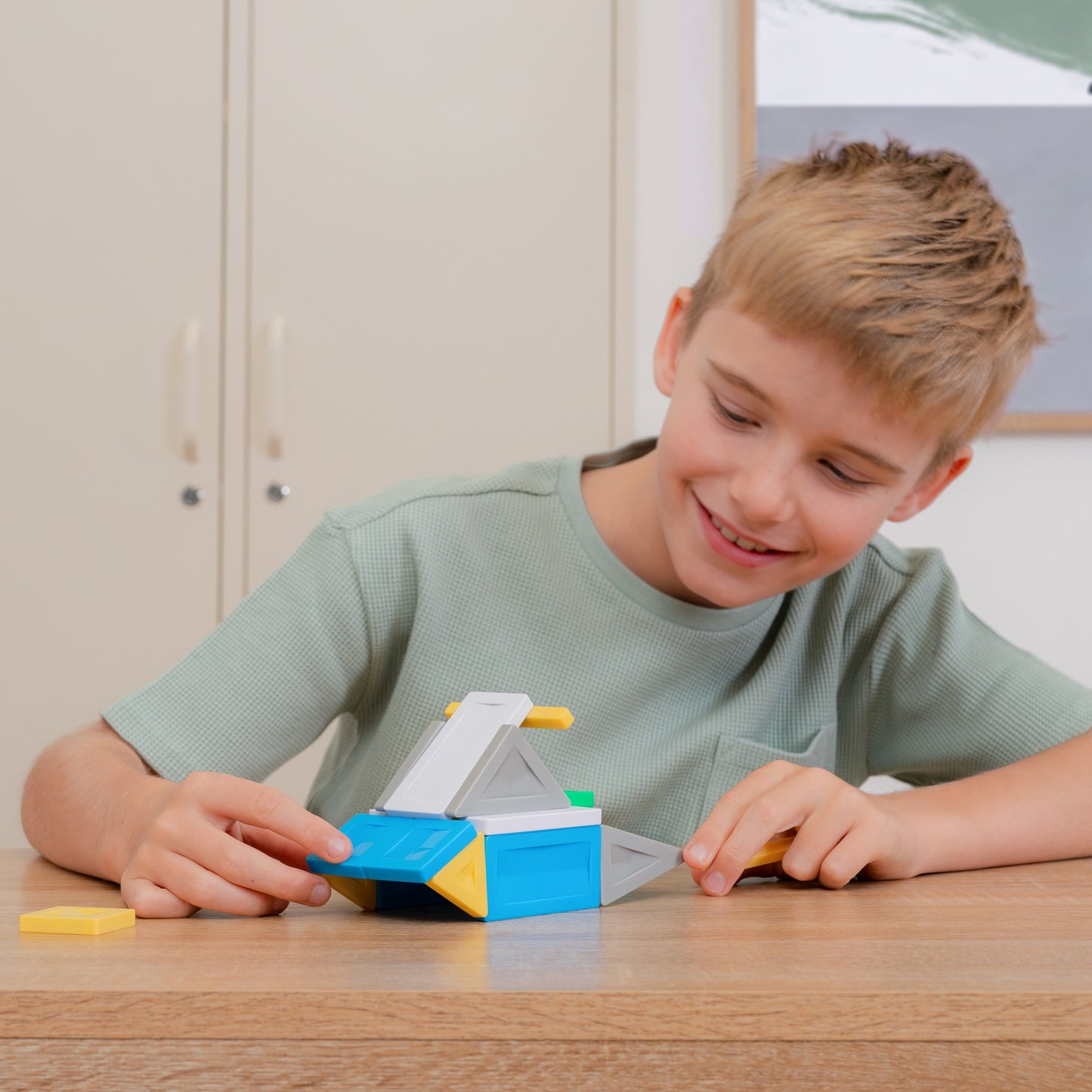 playing with a colorful toy model made of blue, yellow, and gray blocks
