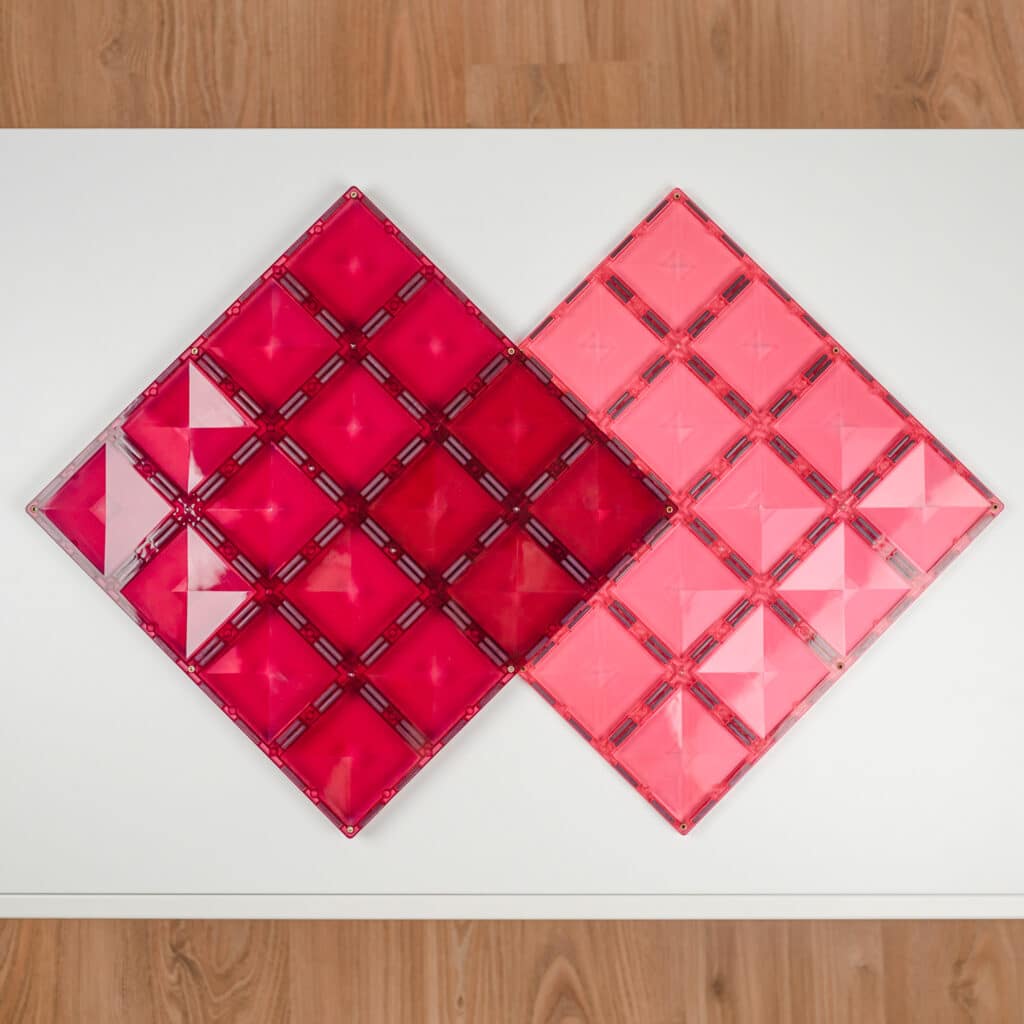 Two pink geometric tile designs on a white surface 