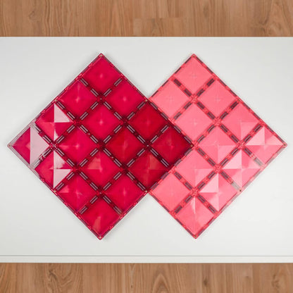 Two pink geometric tile designs on a white surface 