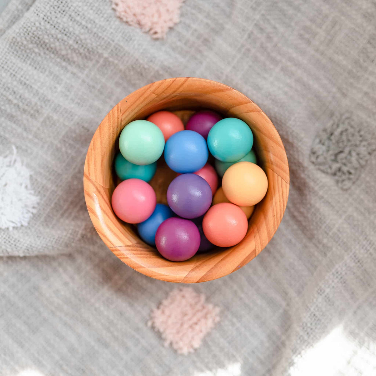 Wooden bowl filled with colorful round objects 