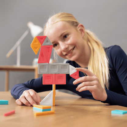 Young girl building with colorful geometric blocks 