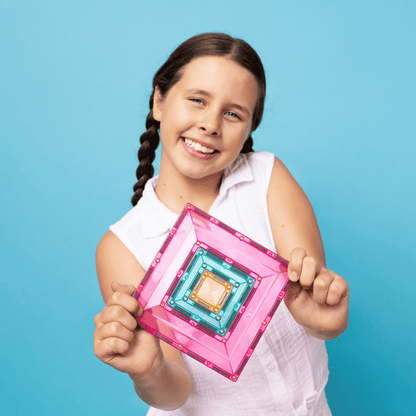 Young girl holding a pink and clear rectangular object 